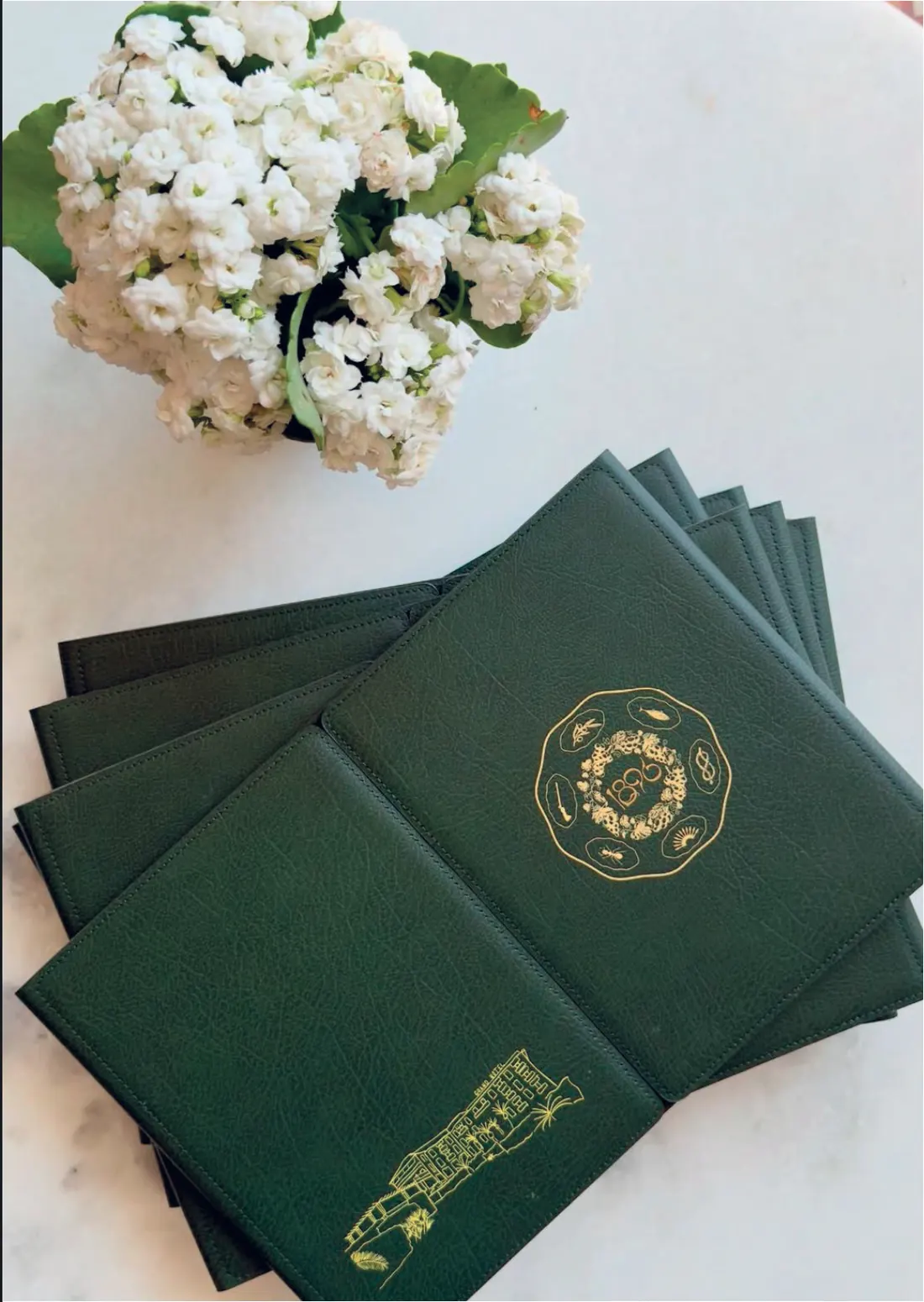Cartes du restaurant en cuir vert, dorure du logo